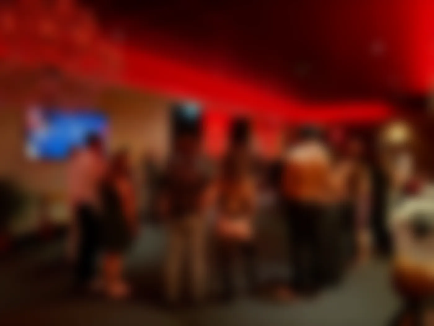 Guests gathering in the red lounge, softened for privacy